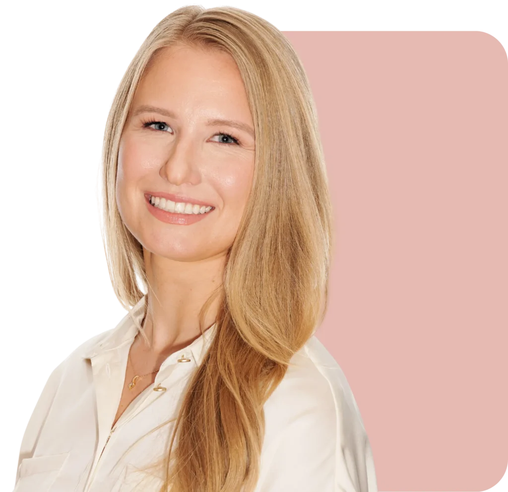 Professional headshot of Dr. Ashley Twynam, smiling warmly in a cream blouse — inviting visitors to begin their coaching journey.