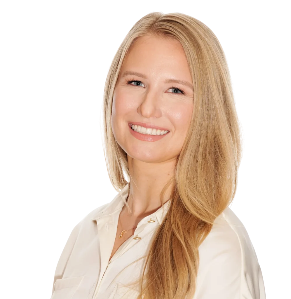 Smiling woman with long blonde hair in a white blouse, professional headshot of Dr. Ashley Twynam.