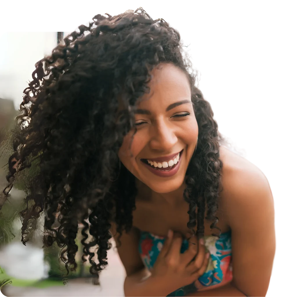 Joyful woman laughing with hand over heart, representing the confidence, clarity, and emotional freedom clients experience through coaching with Dr. Ashley.